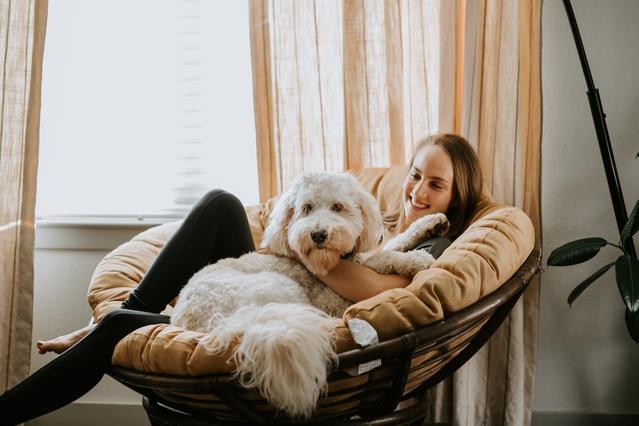 Woman relaxing with a happy dog lying on her lap